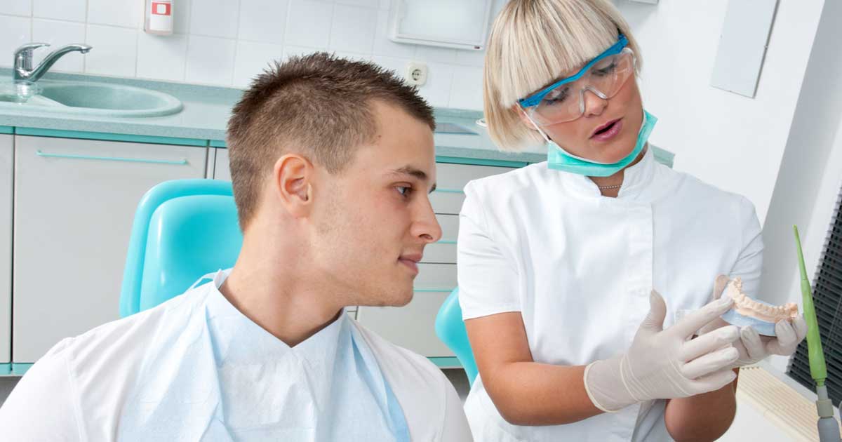 Hygienist Showing Tooth Model for Implants